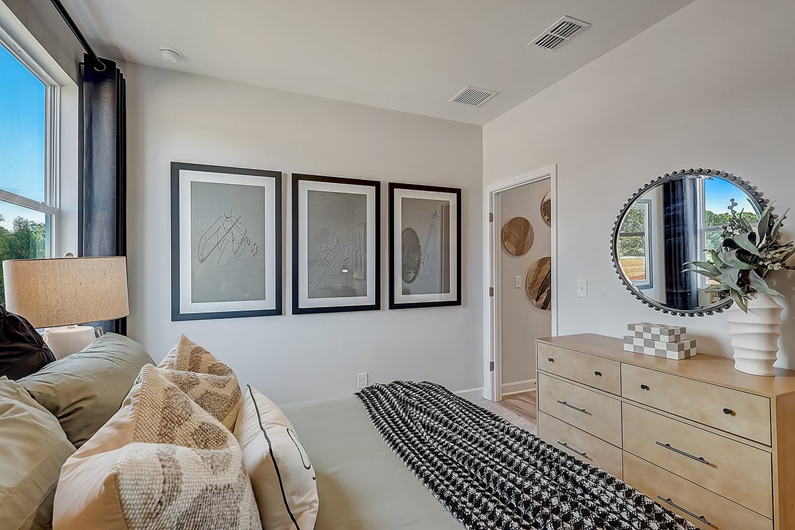 A bedroom with a bed and a mirror.