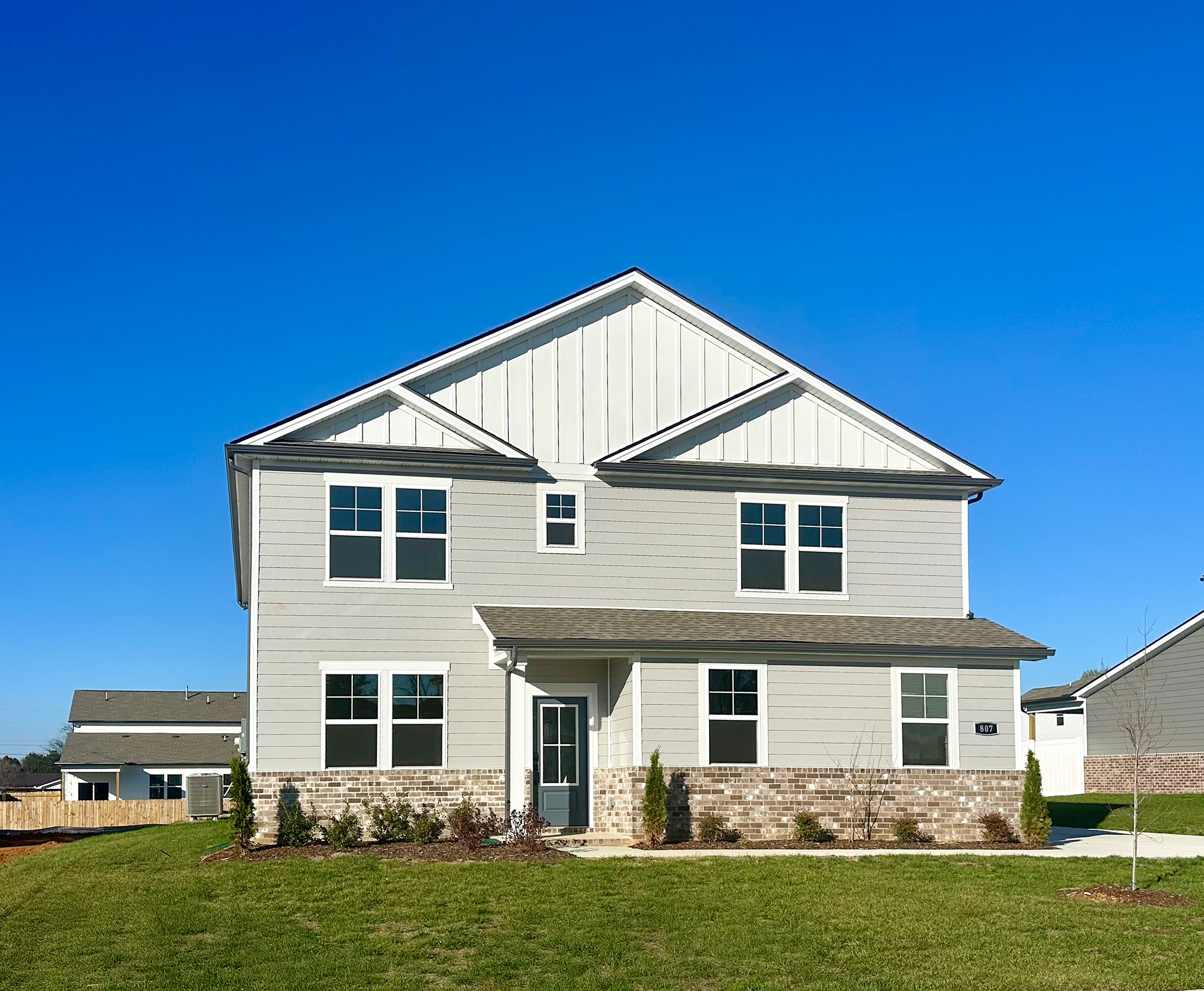 A white house with a grass yard.