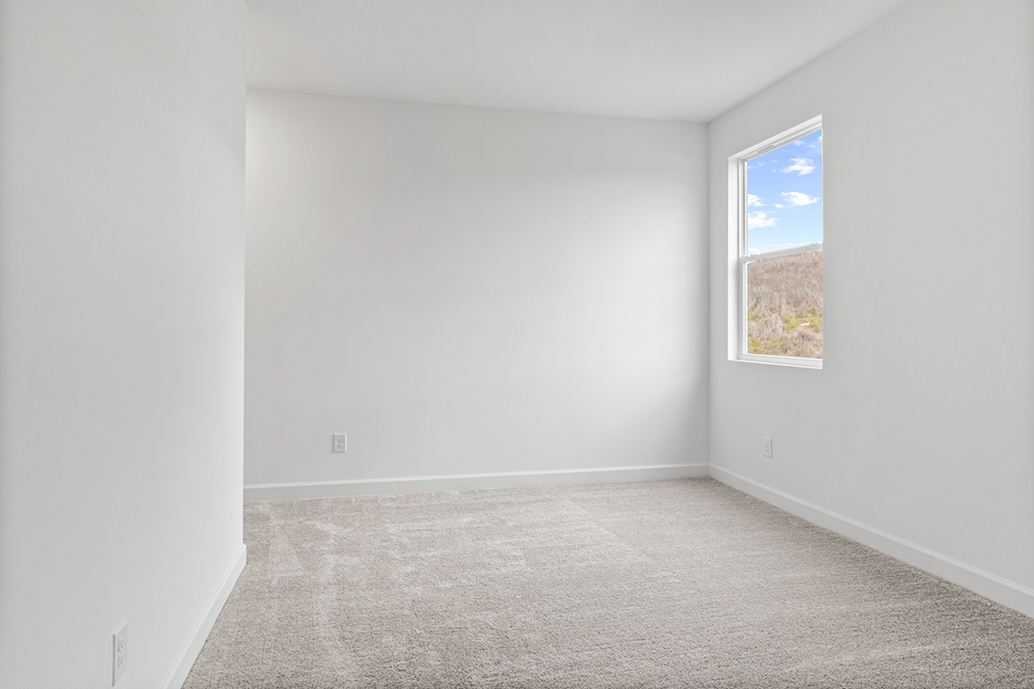 A room with a window and carpet.