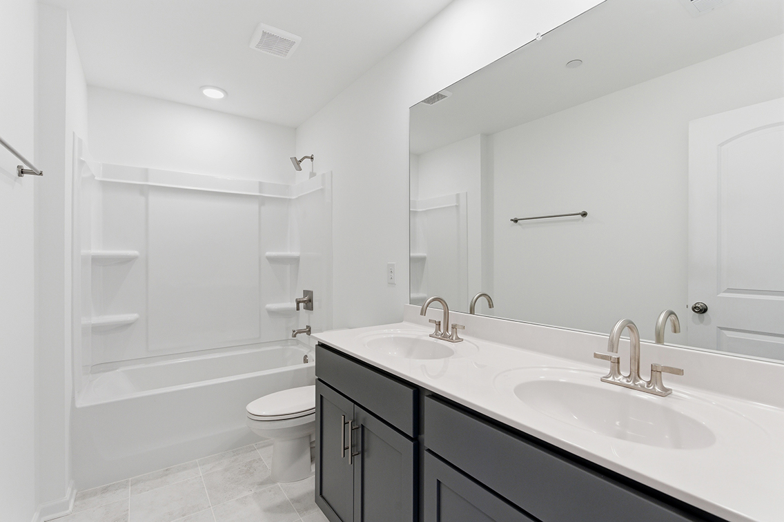 A bathroom with a tub sink and toilet.