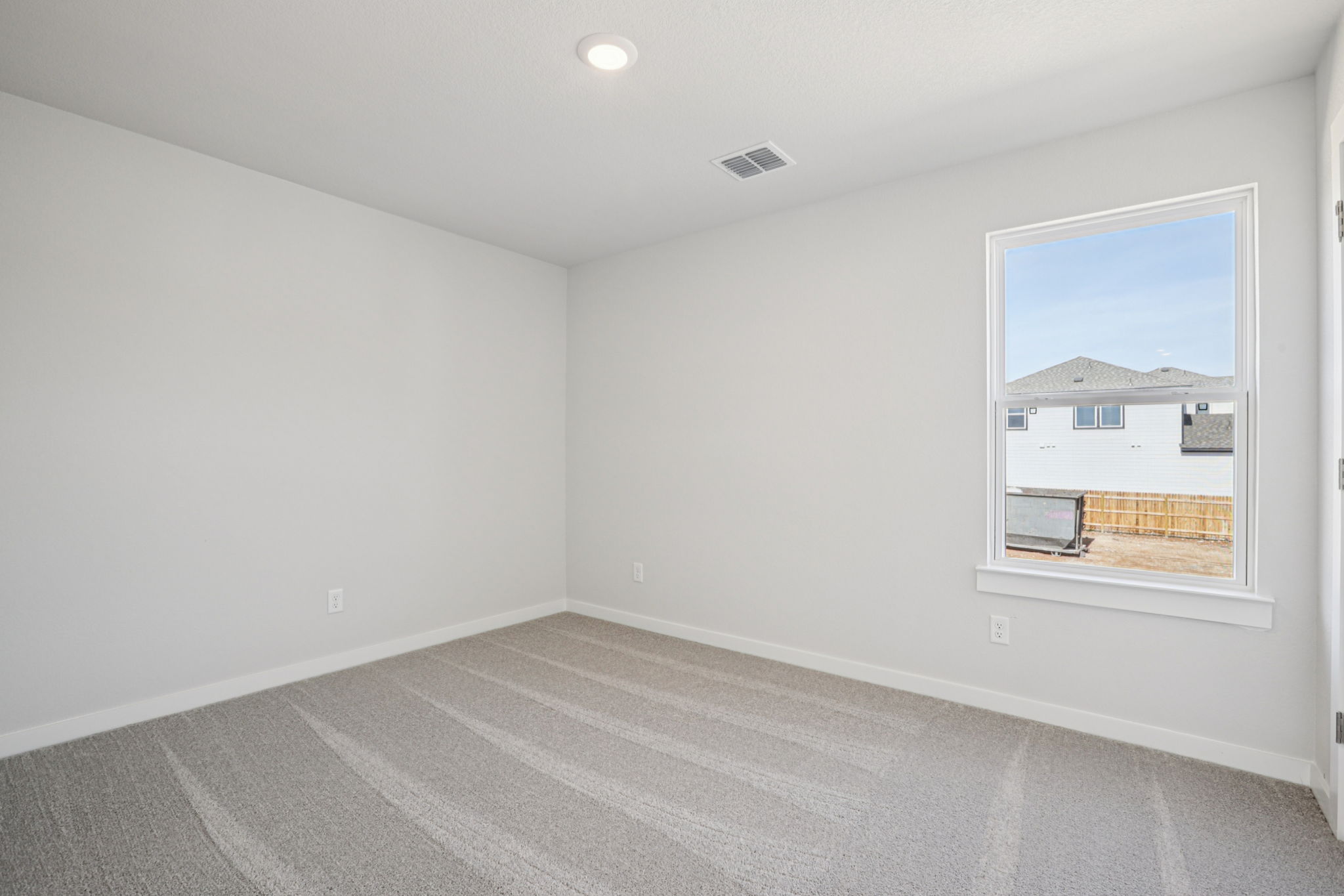 A room with a window and a rug.