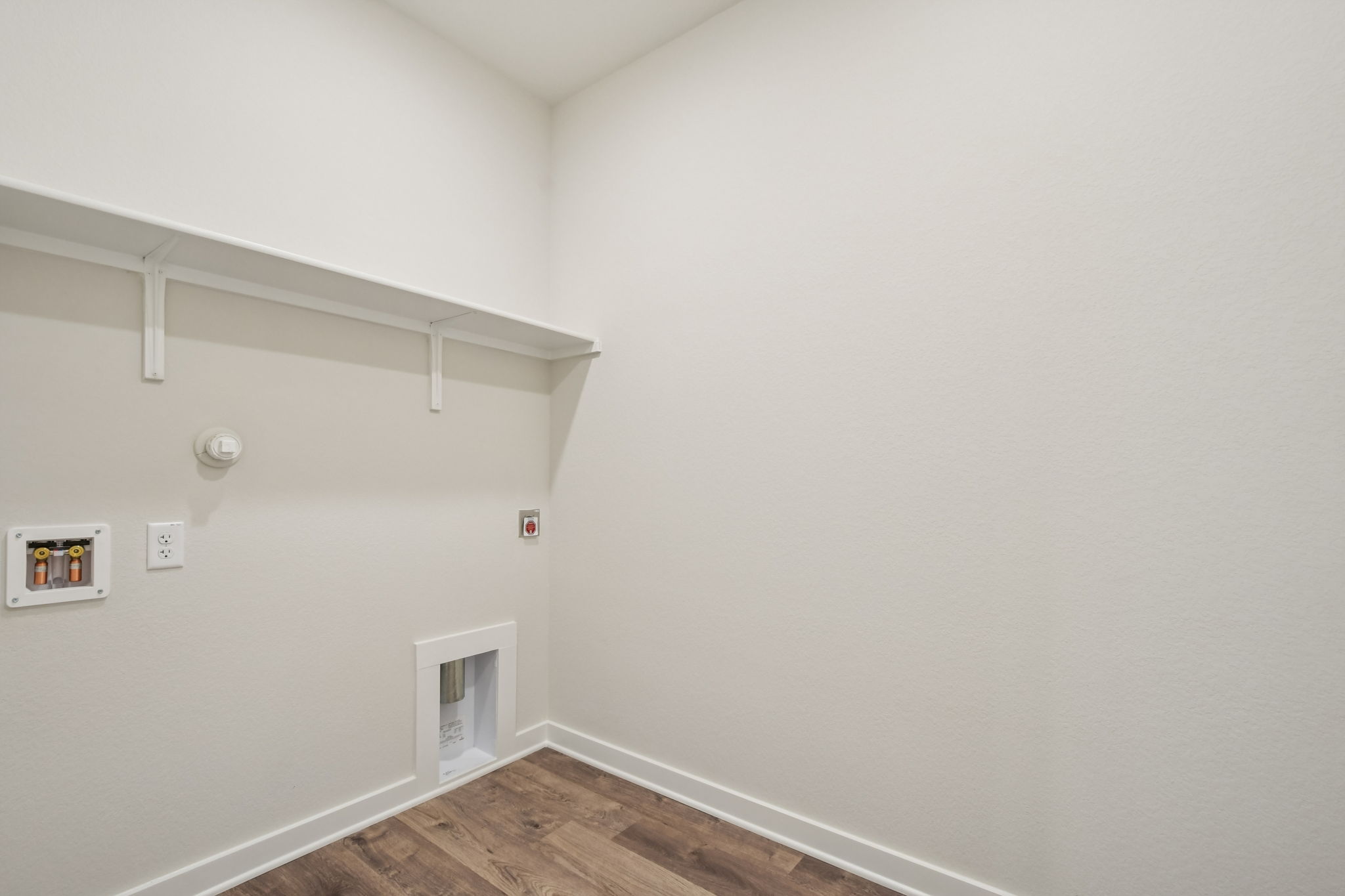 A white room with a wood floor and a wood floor.