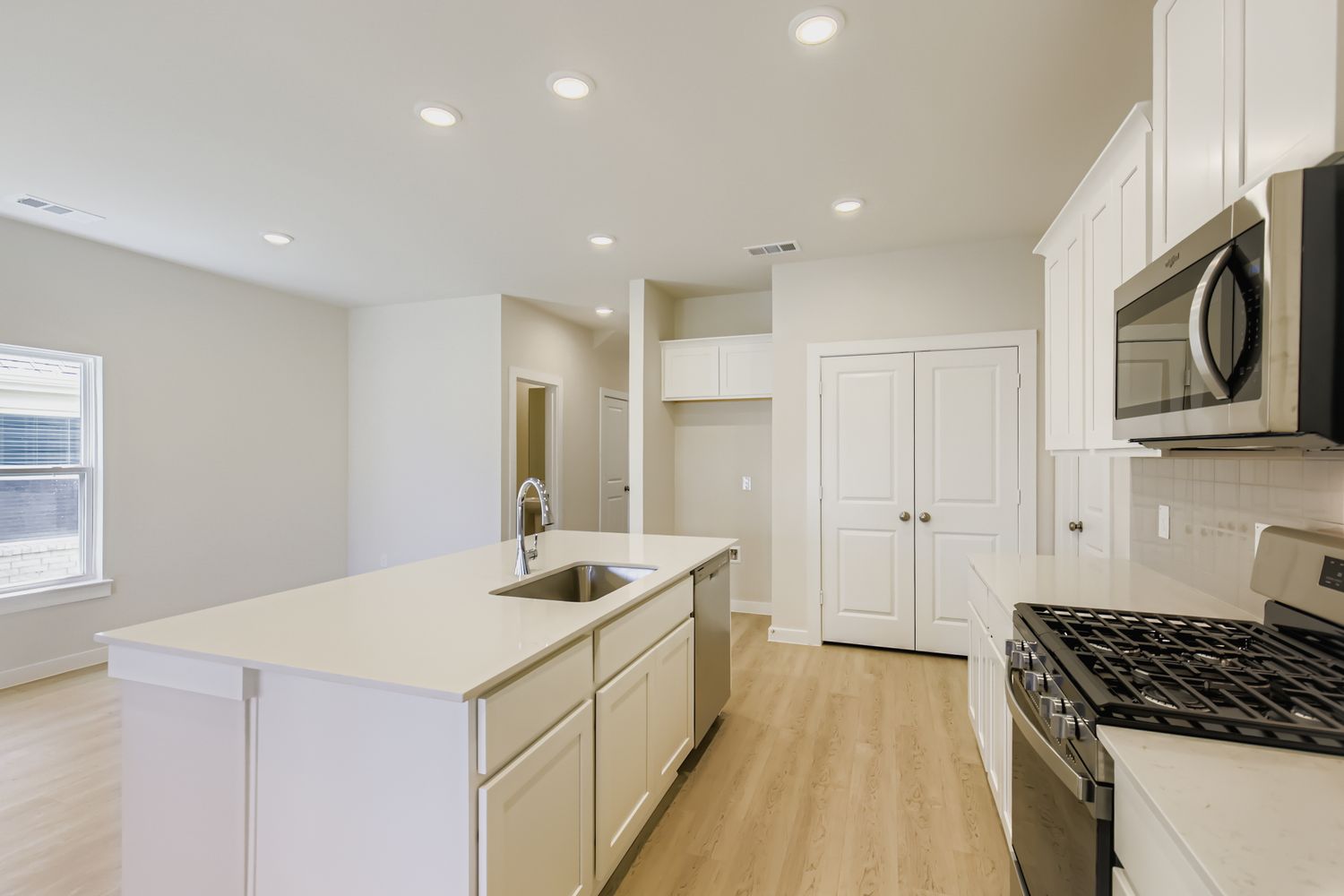 A kitchen with white cabinets.