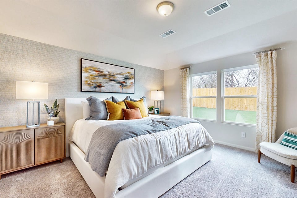 A bedroom with a bed and lamps.