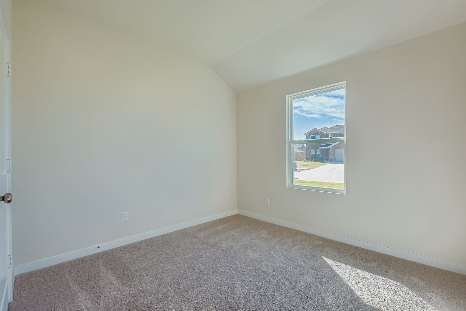 A room with a window and carpet.