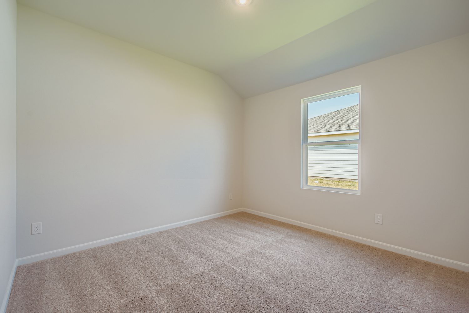 A room with a carpet and a window.