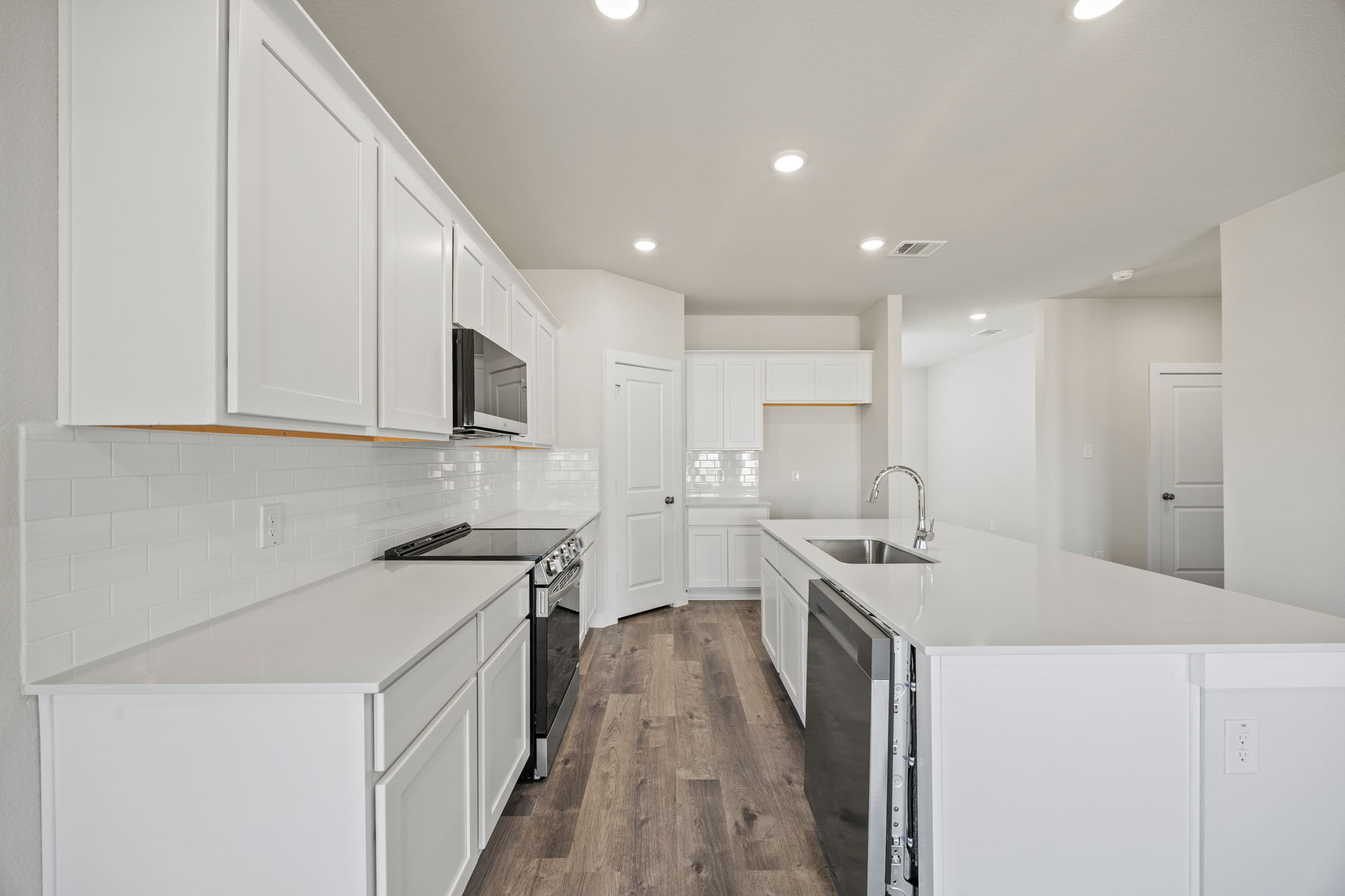 A kitchen with white cabinets.