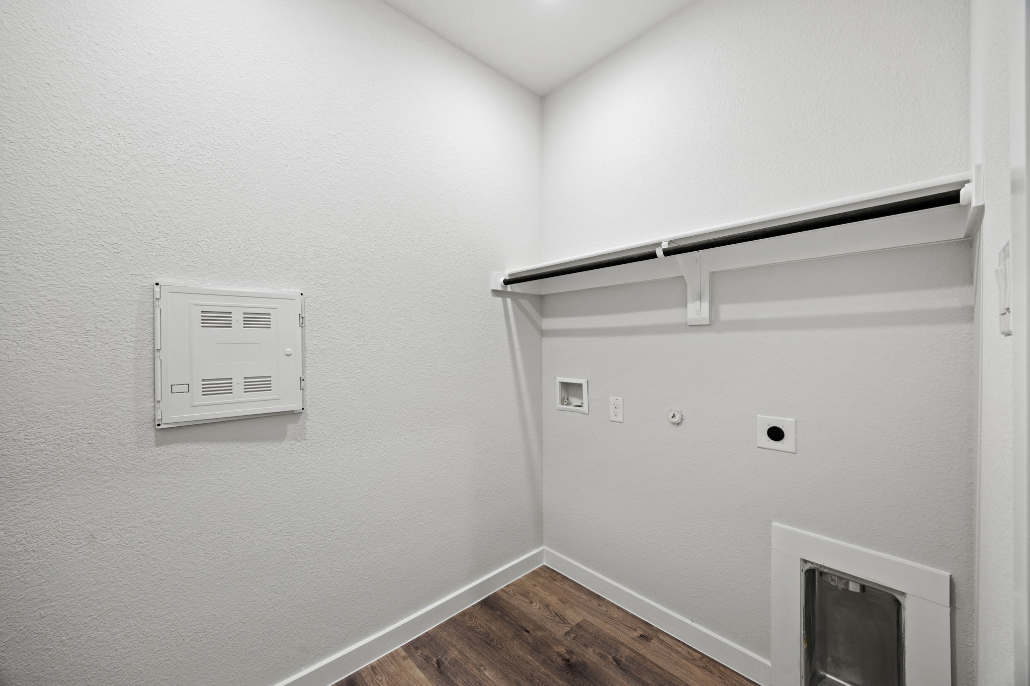 A white wall with a white shelf and a white wall with a white square object on it.