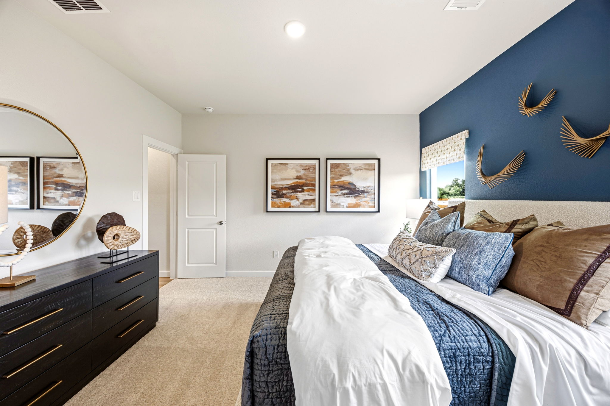 A bedroom with a bed and a mirror.