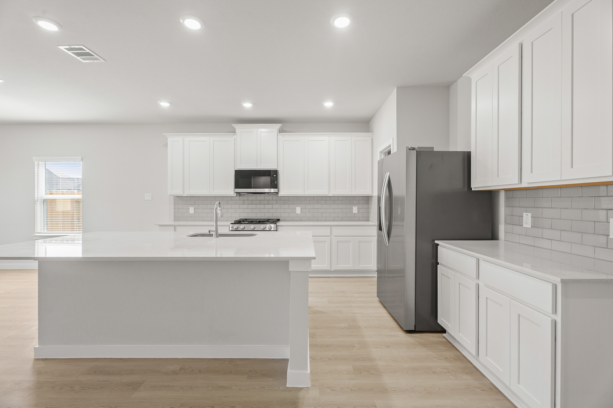 A kitchen with white cabinets.