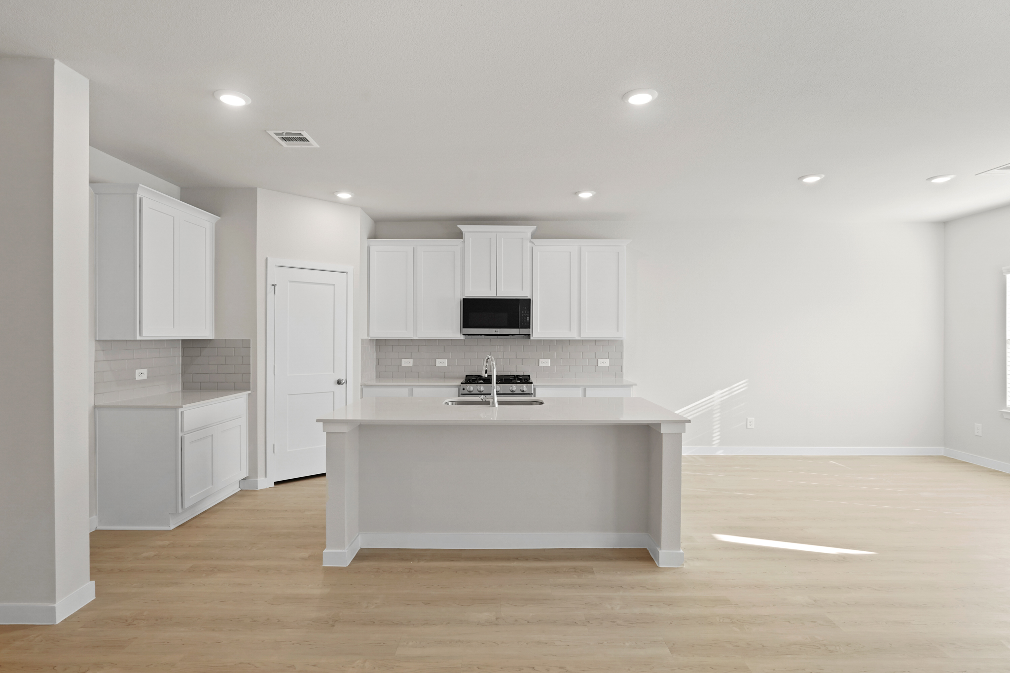A kitchen with white cabinets.