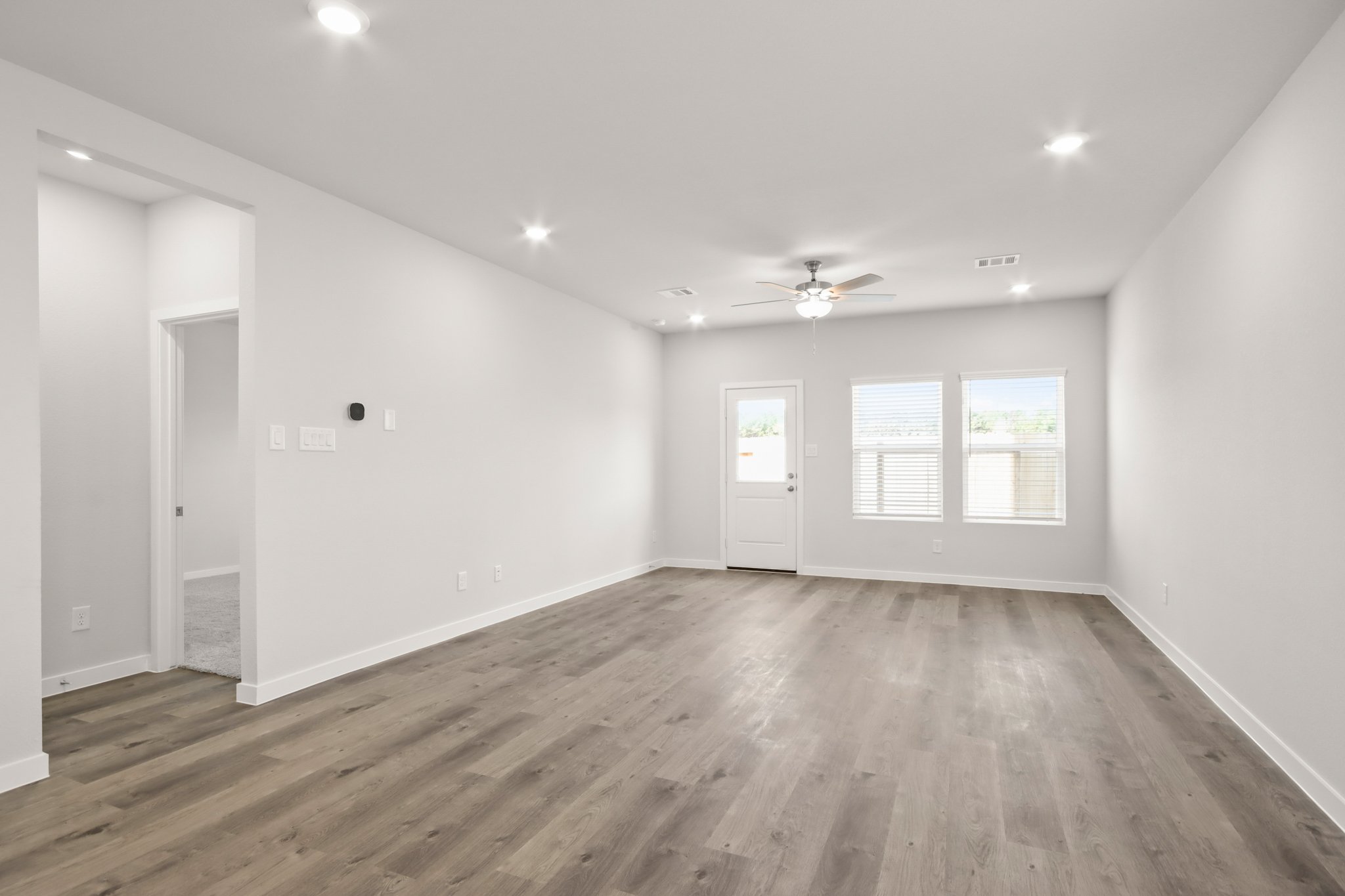 A room with a wood floor and a ceiling fan.