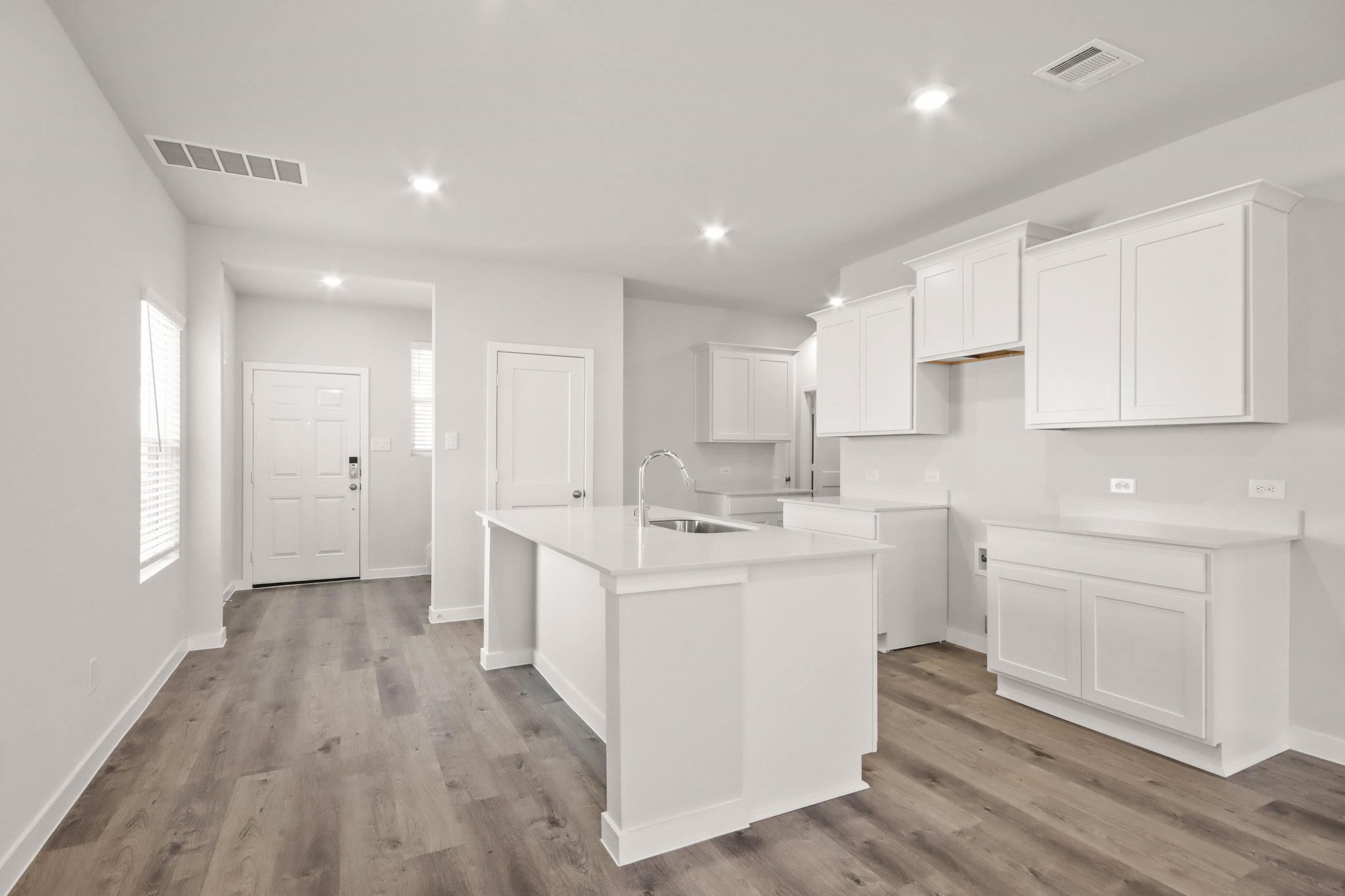 A kitchen with white cabinets.