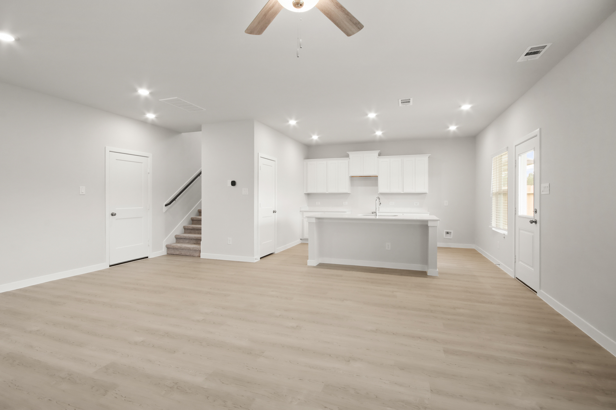 A large empty room with white cabinets.