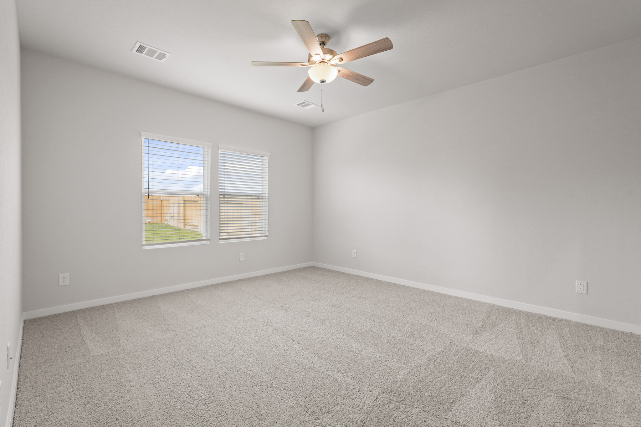 A room with a ceiling fan and a window.