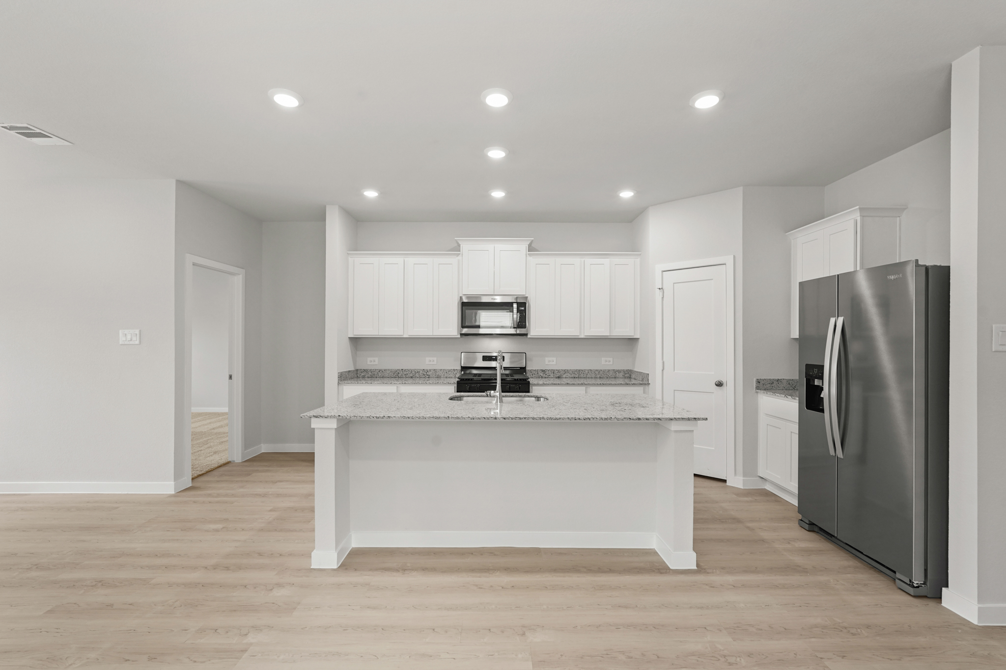 A kitchen with white cabinets.