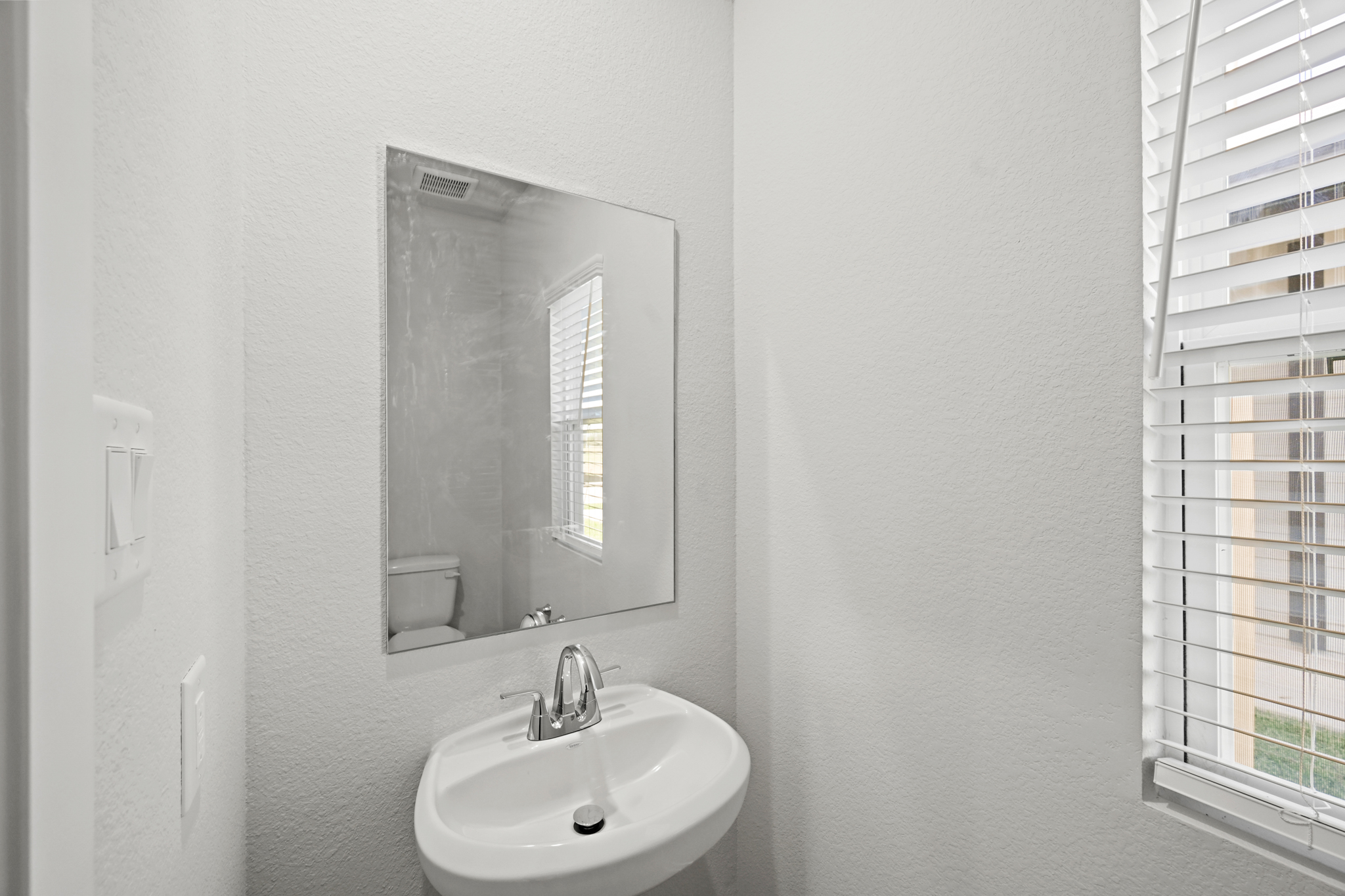 A bathroom with a mirror and sink.