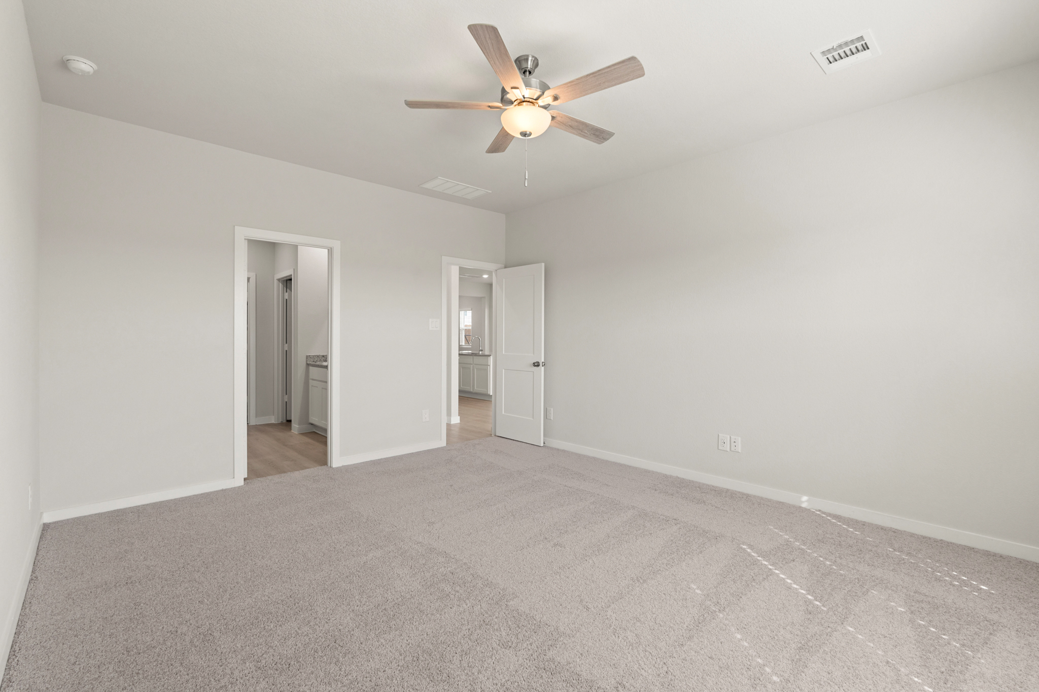 A room with a ceiling fan and a door.