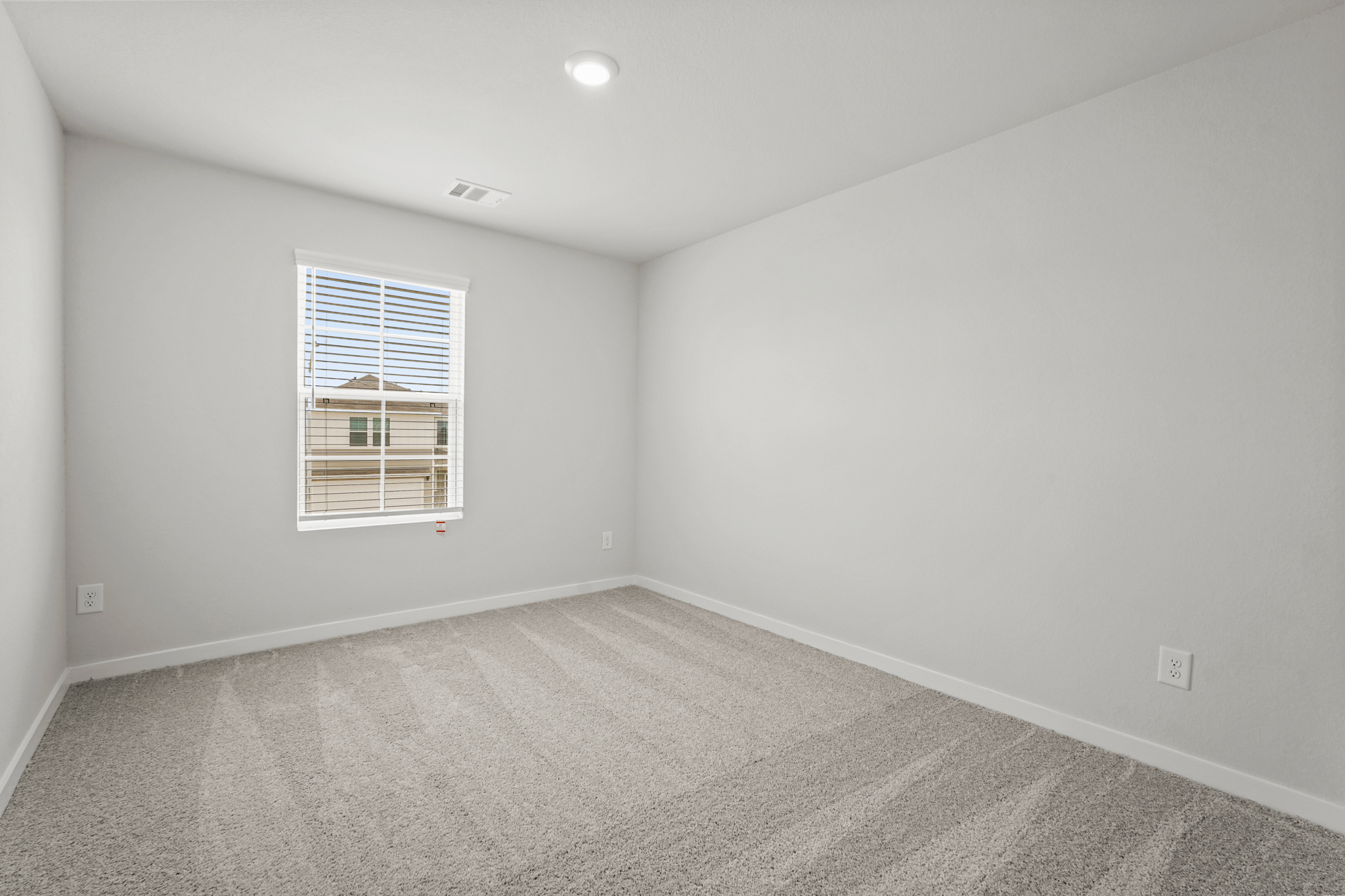 A room with a window and a carpet.