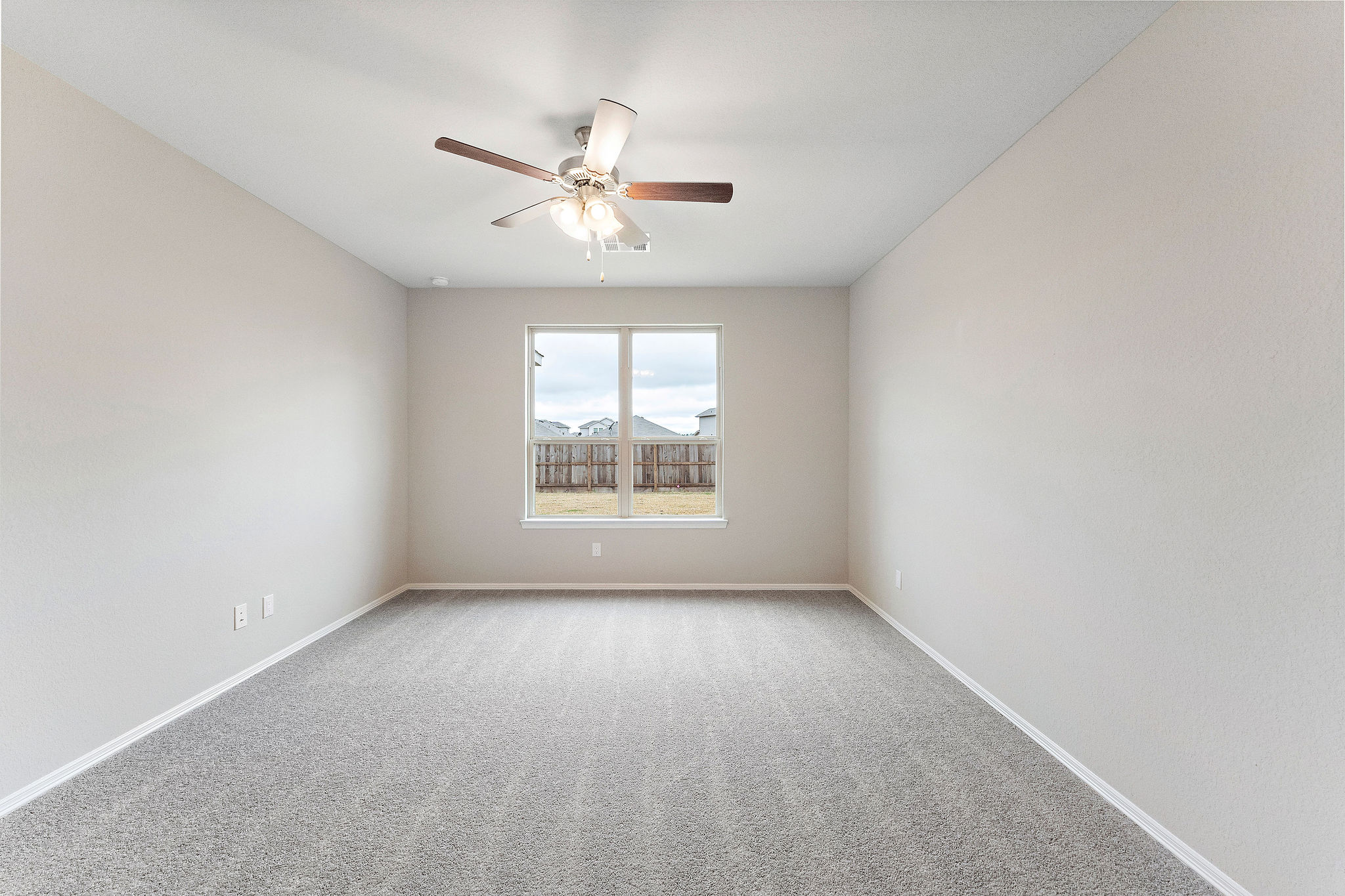 A room with a ceiling fan and a window.