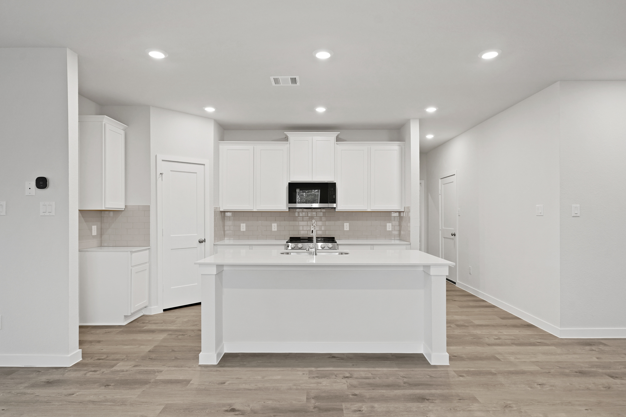 A kitchen with white cabinets.