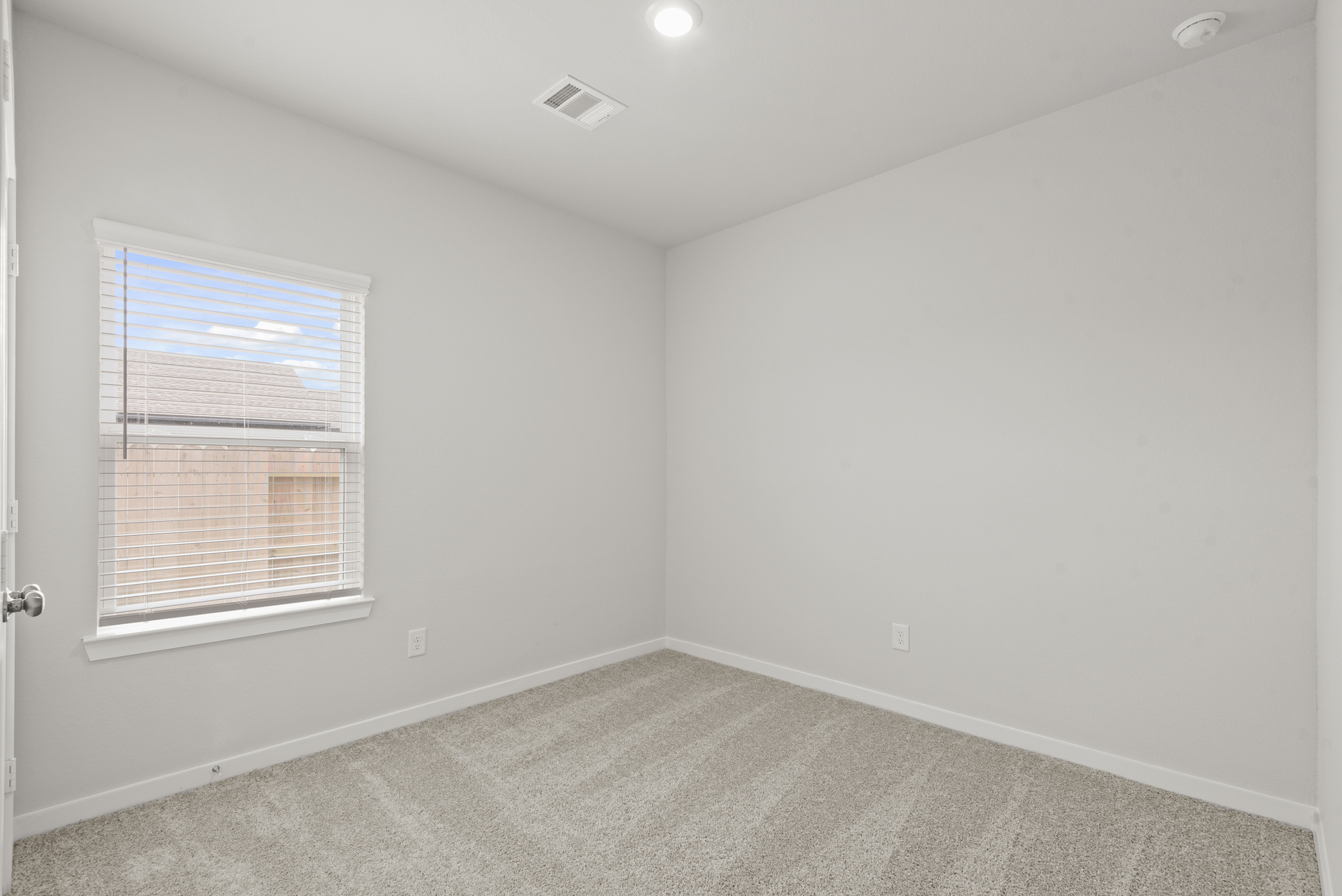 A room with a window and a carpet.