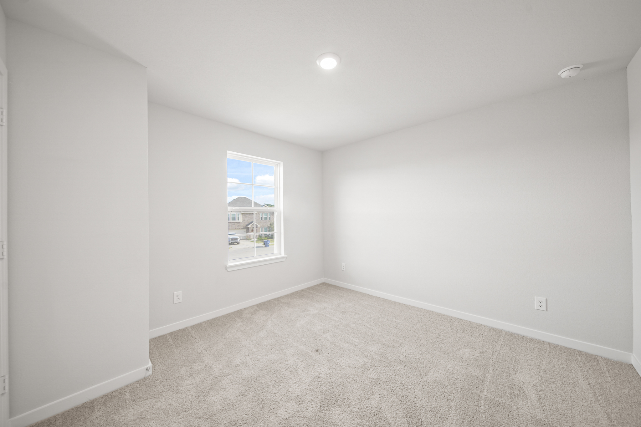 A room with a window and a carpet.