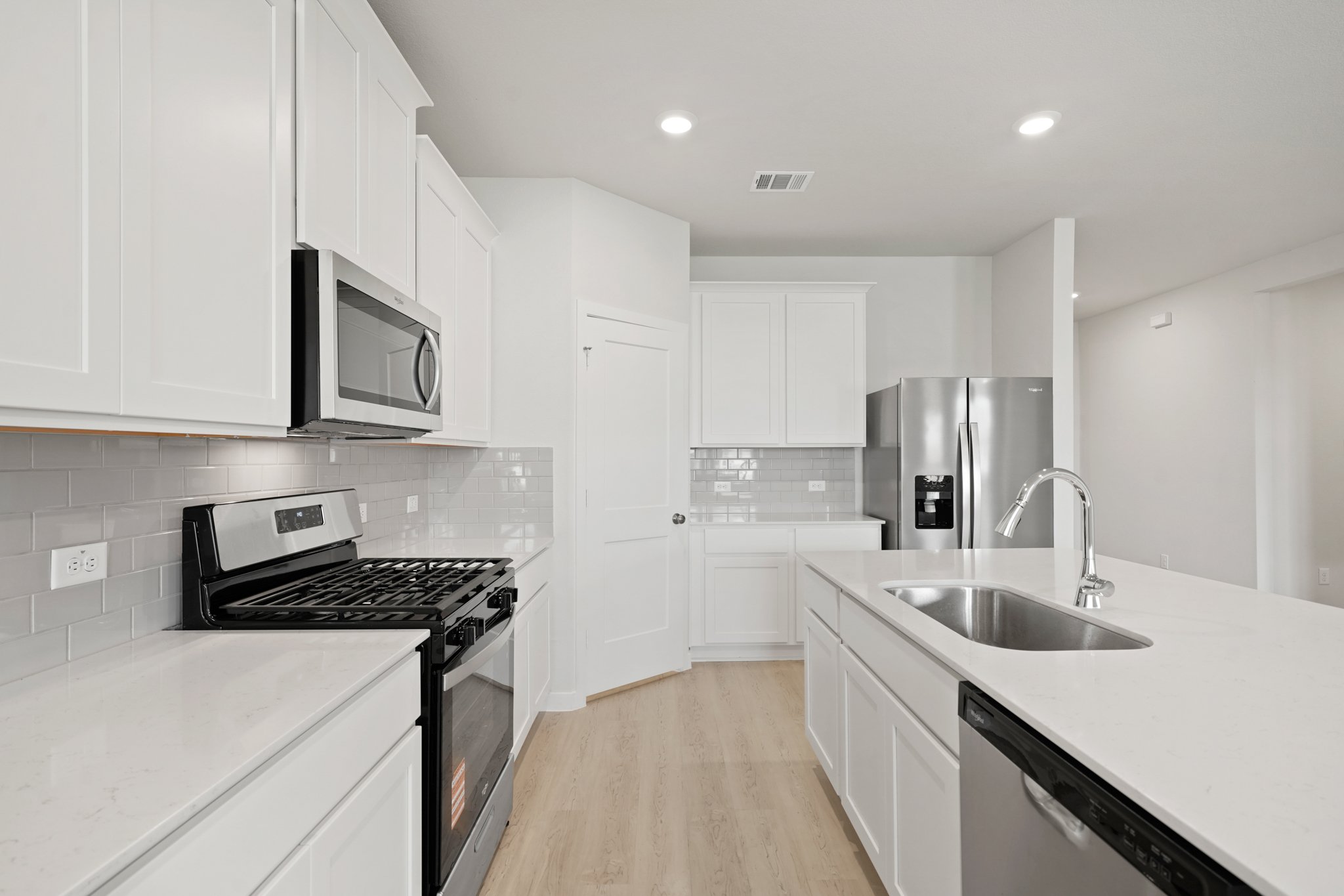 A kitchen with white cabinets.
