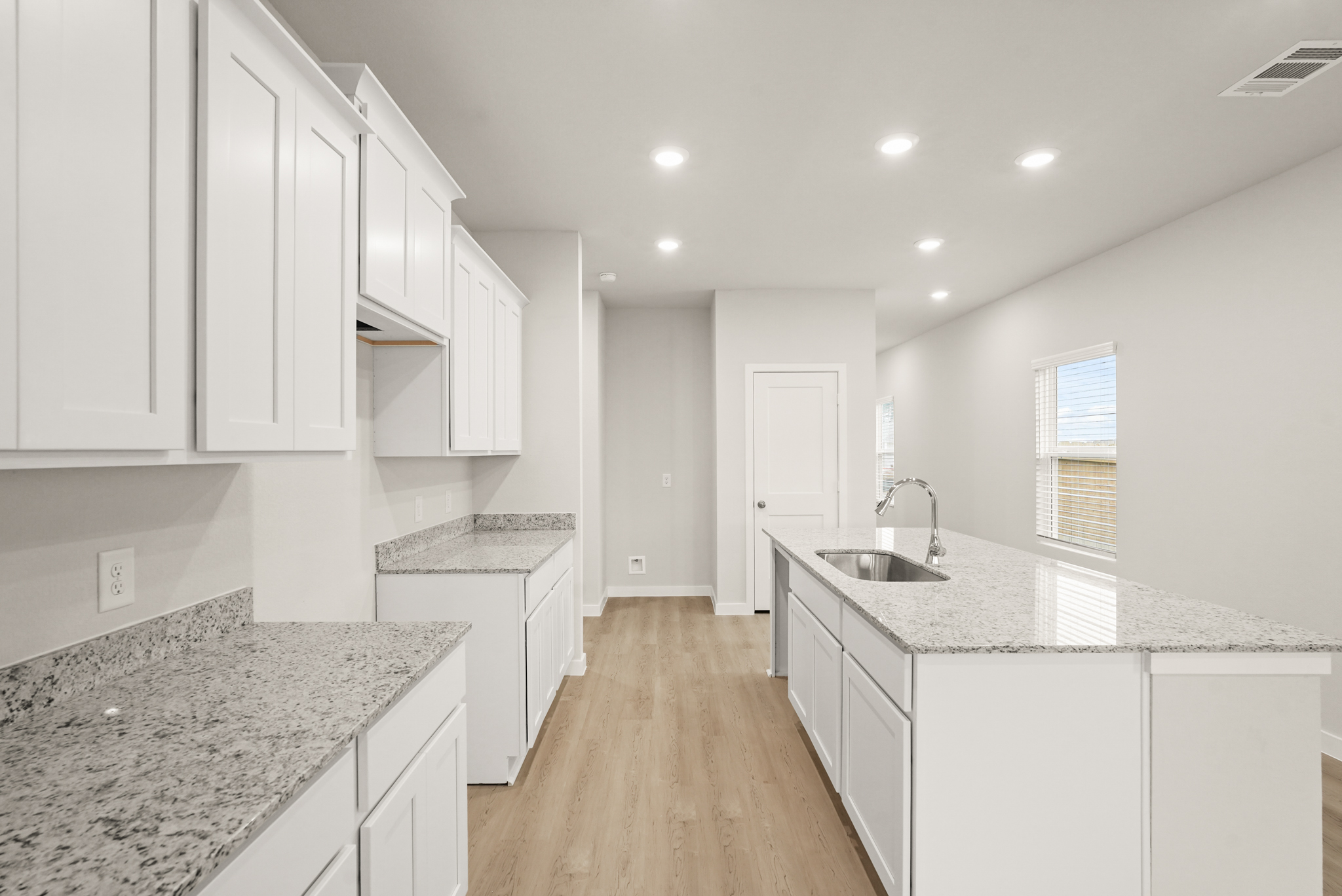A kitchen with white cabinets.