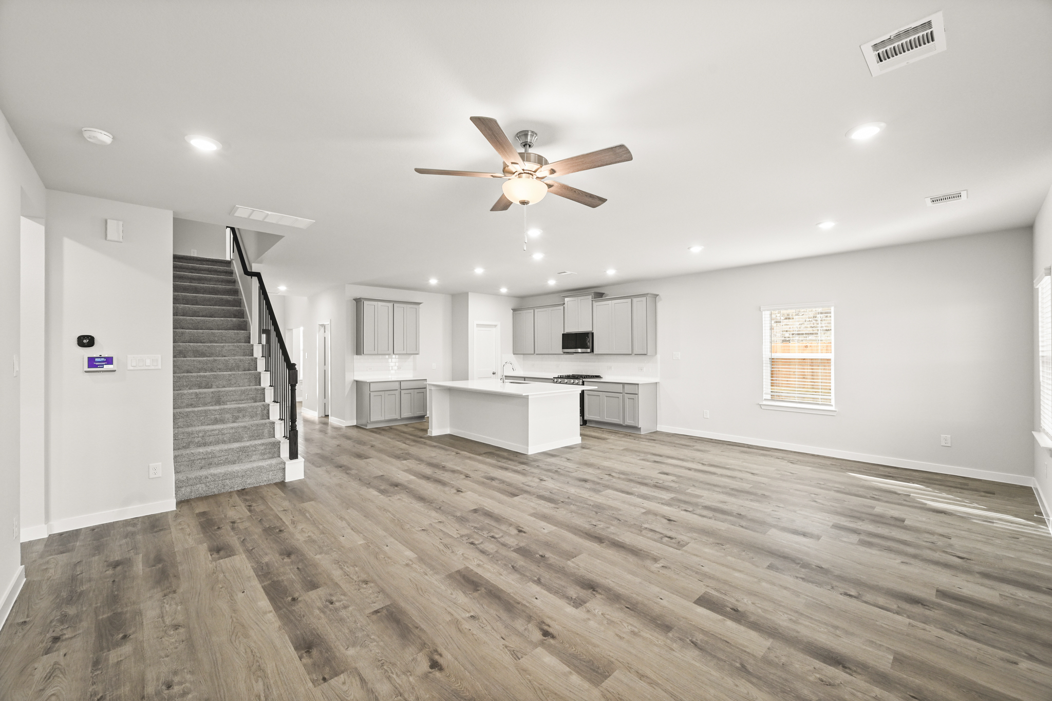 A large empty room with a wood floor and a wood floor.