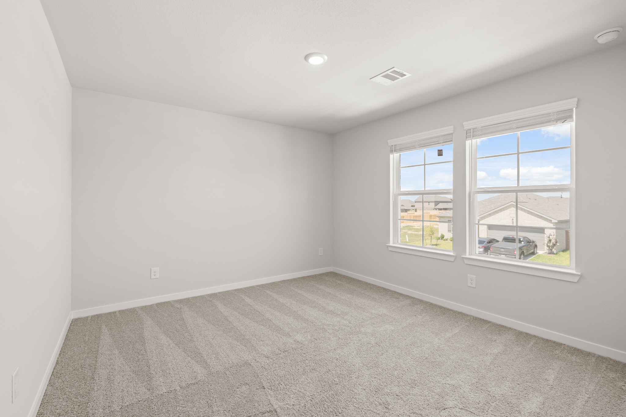 A room with windows and a carpet.
