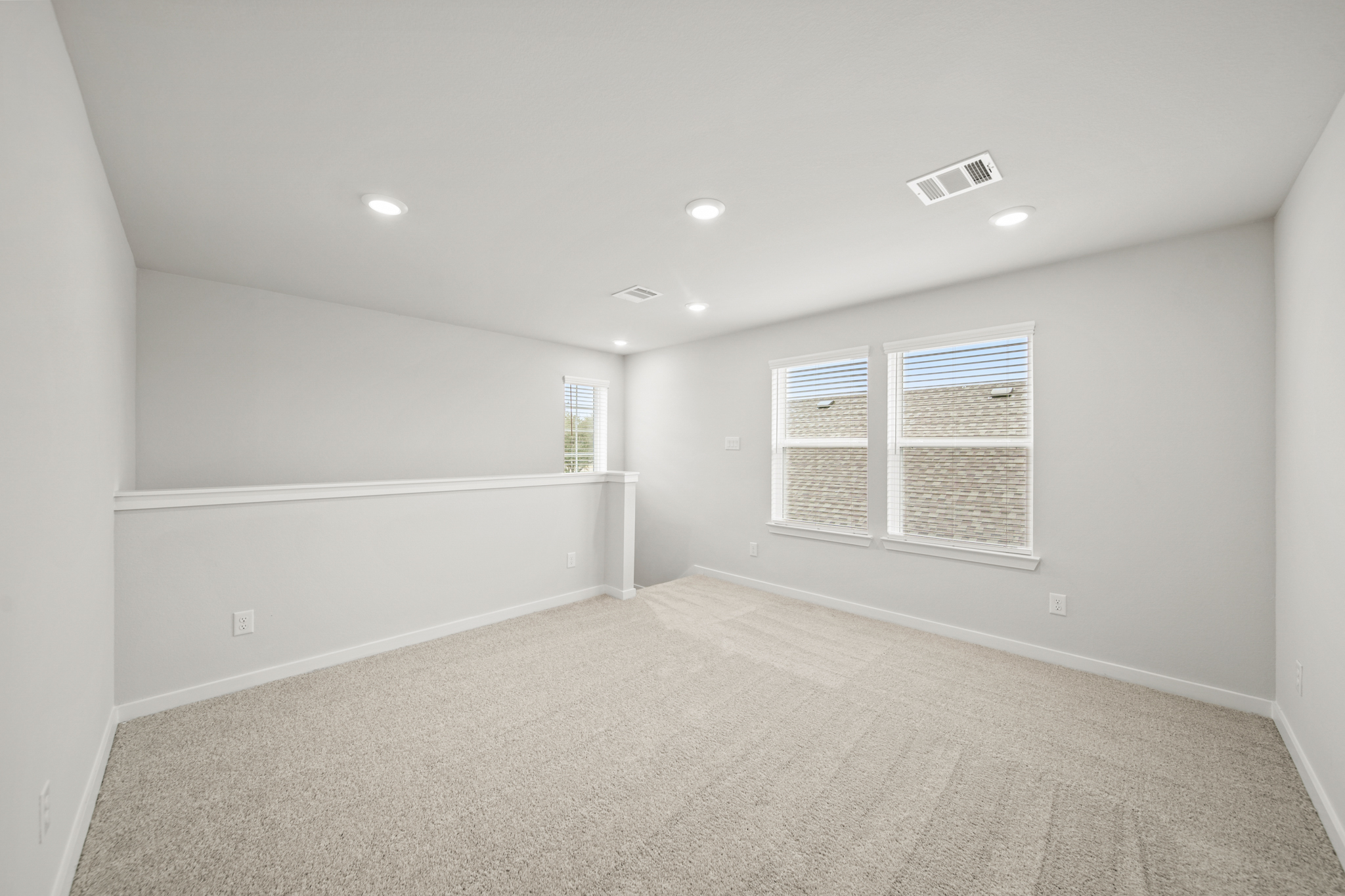 A room with a white wall and a window.