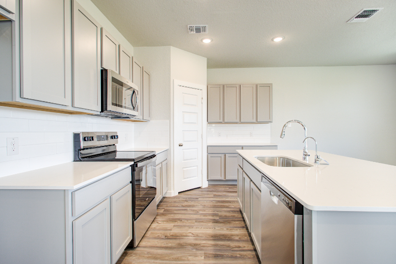 A kitchen with white cabinets.