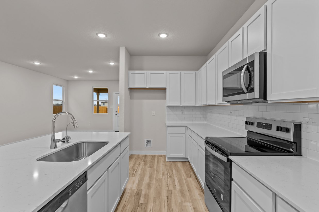 A kitchen with white cabinets.