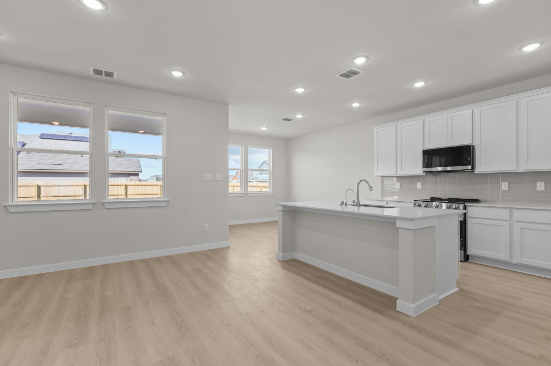 A kitchen with white cabinets.