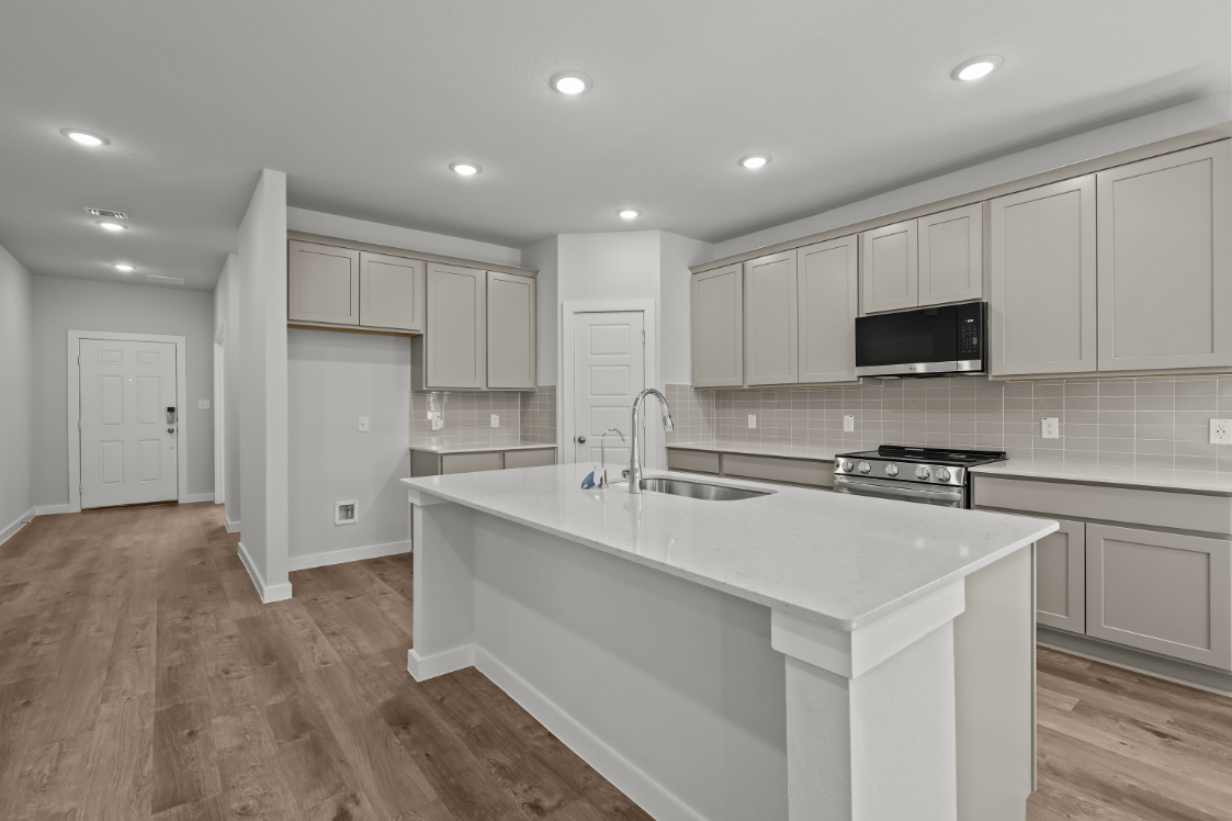 A kitchen with white cabinets.