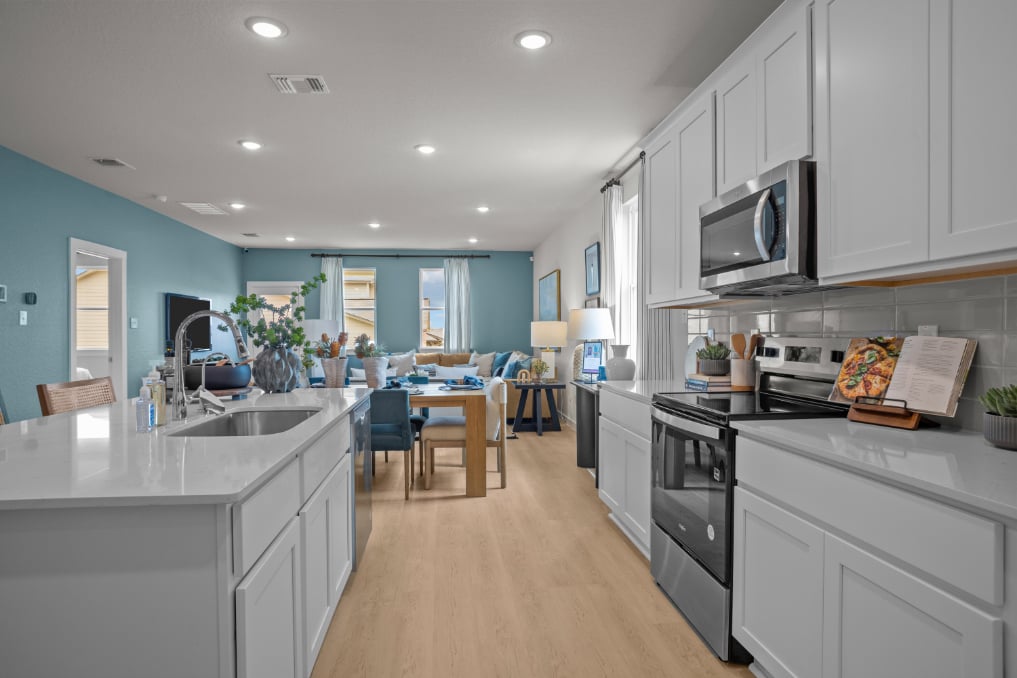 A kitchen with white cabinets.