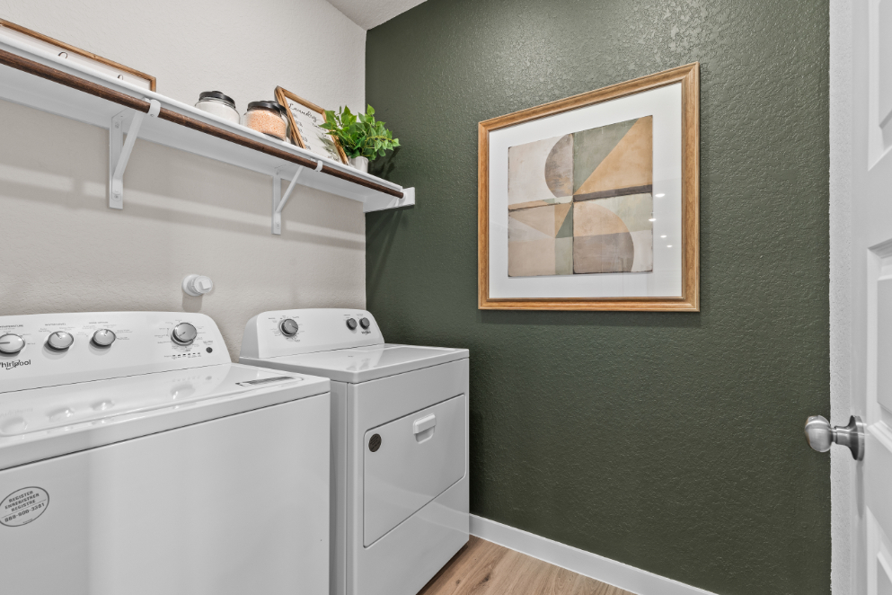 A white laundry room with a white washer and dryer.
