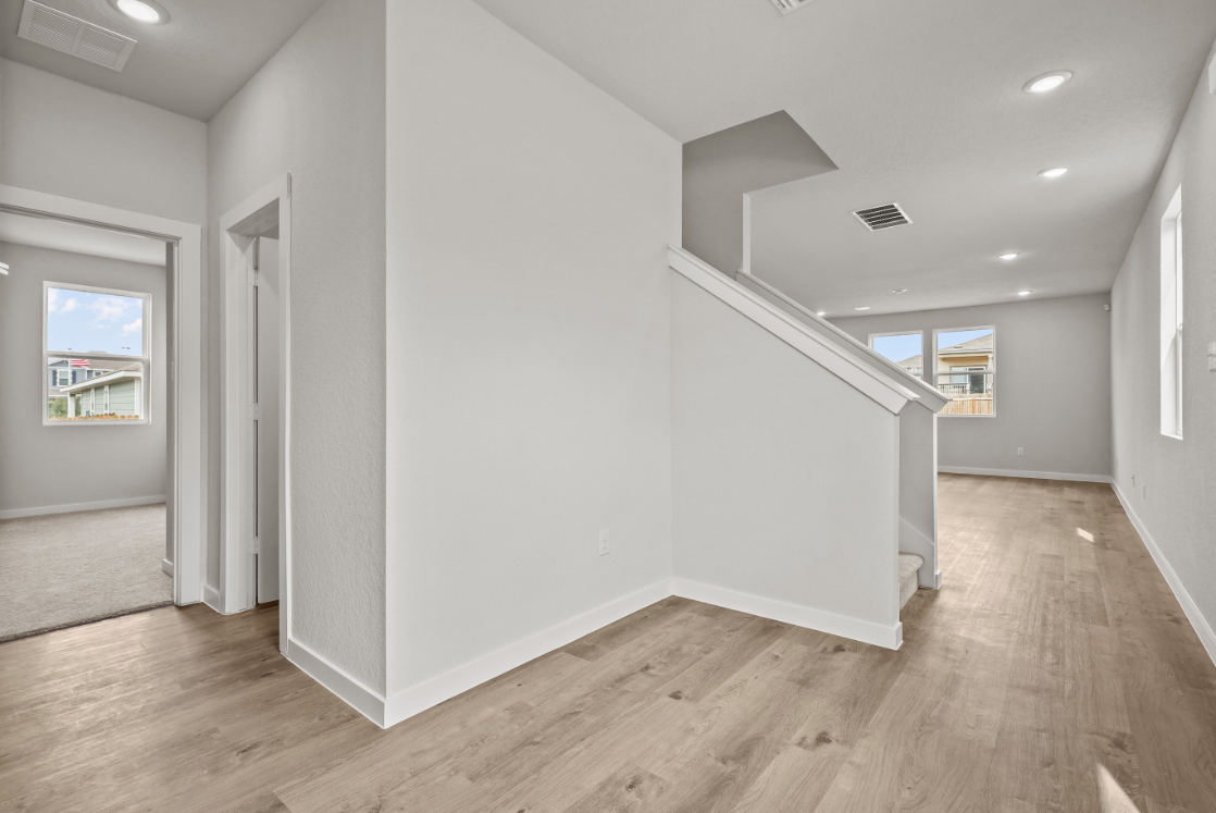 A white room with a wood floor.