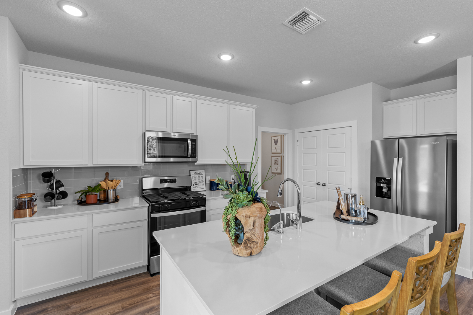 A kitchen with white cabinets.