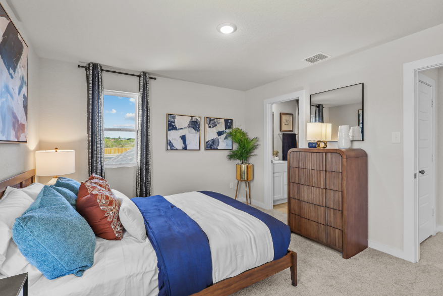 A bedroom with a bed and a dresser.
