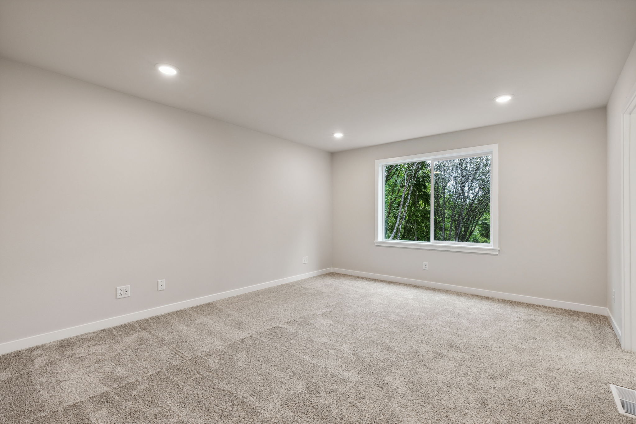 A room with a window and a rug.