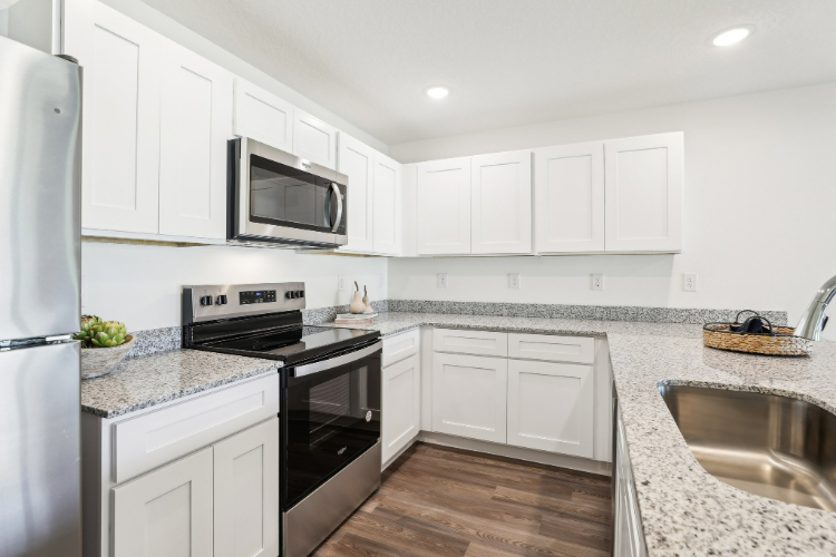 A kitchen with white cabinets.