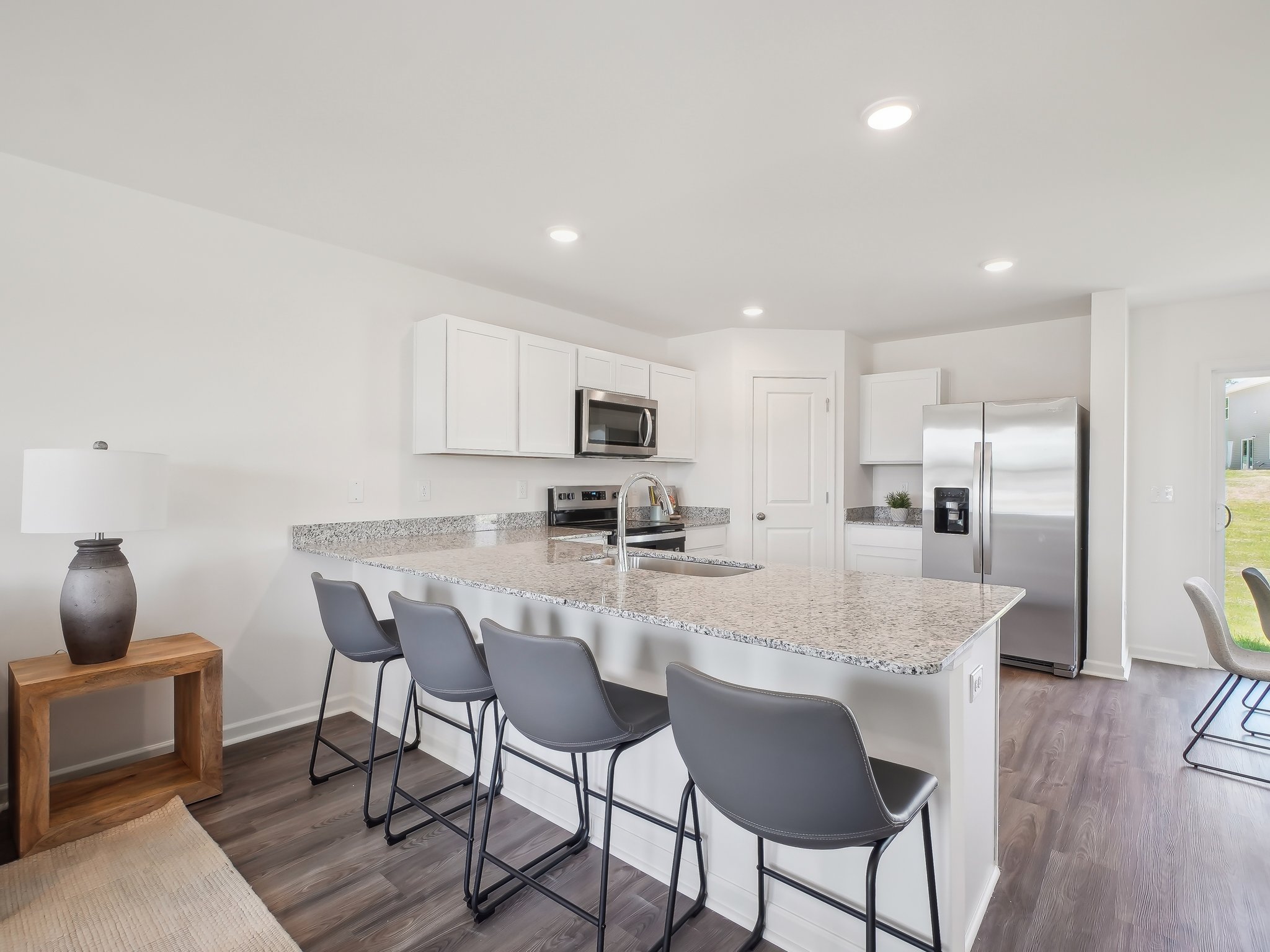 A kitchen with a dining table and chairs.