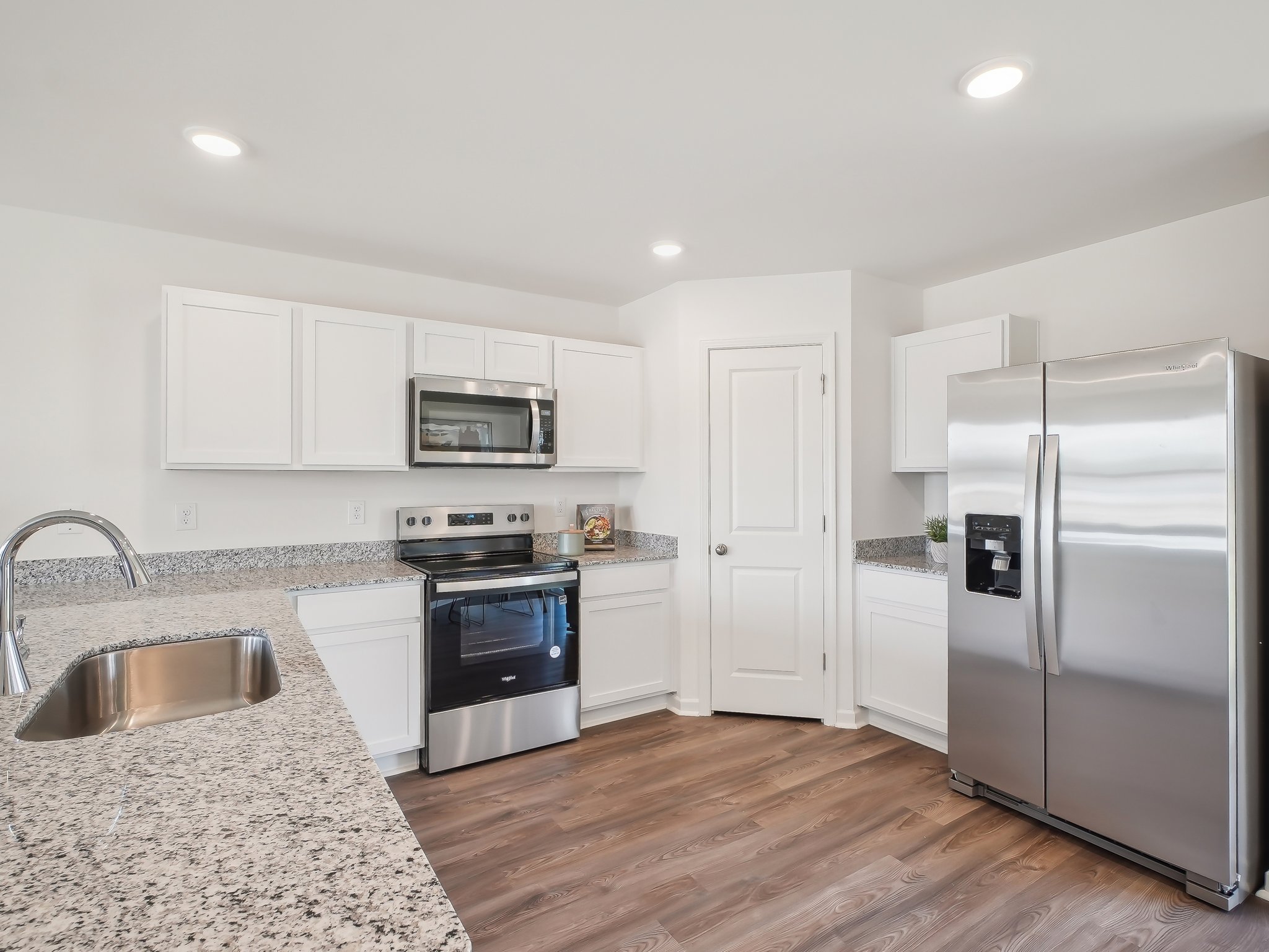 A kitchen with white cabinets.