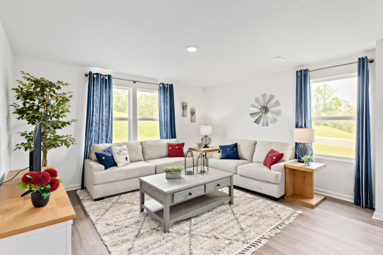 A living room with a white couch and a table with a white table.