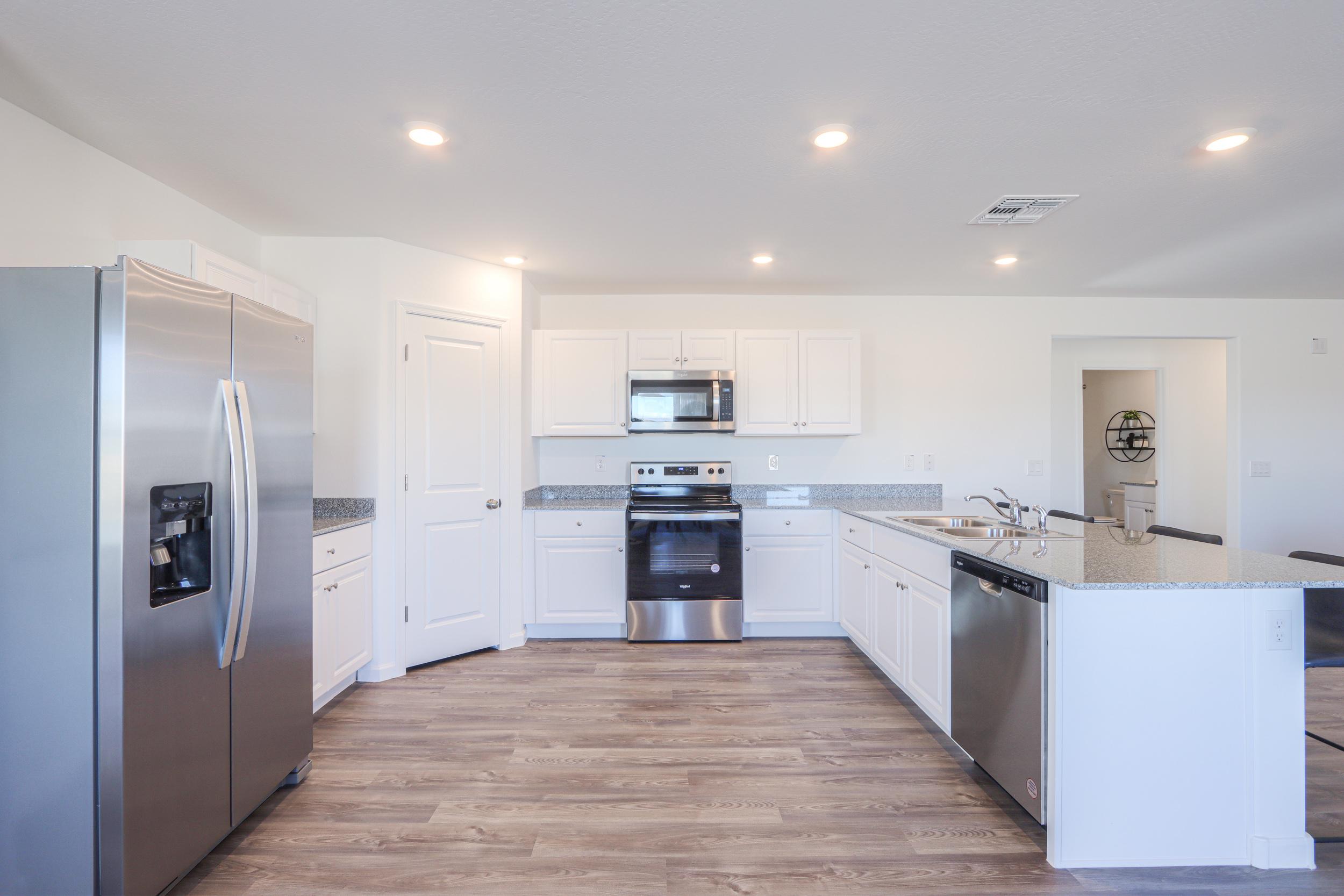 A kitchen with white cabinets.